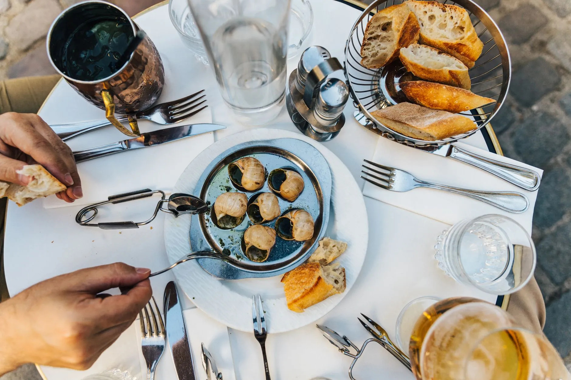 Table de bistrot parisien avec escargots, pain et vin