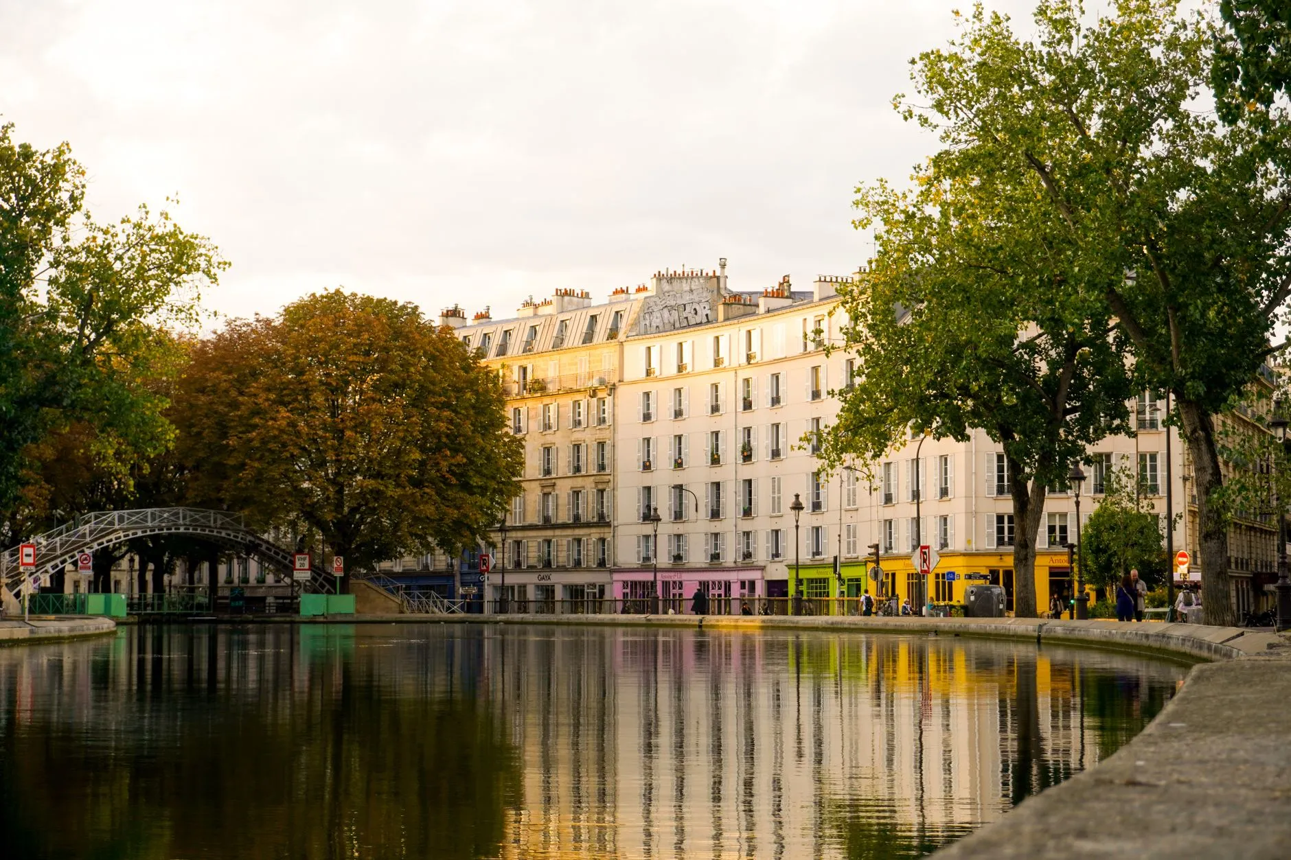 Les bords du Canal Saint-Martin à Paris, avec sa passerelle en fer et les boutiques colorées du quai de Valmy